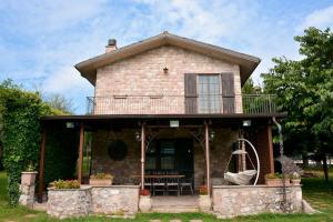 a house with a balcony and a swing at VILLA LIA, casa in collina con piscina. in Porello