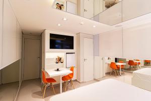 a room with a bed and a table and chairs at Nuu Motel in São Paulo
