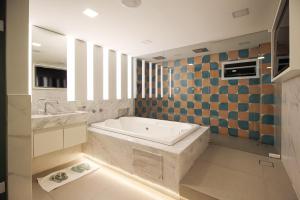 a bathroom with a tub and a sink at Nuu Motel in São Paulo