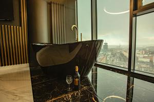 - Baño con lavabo negro y botella de vino en Wanna na 20 piętrze, City View, Hanza Tower, en Szczecin