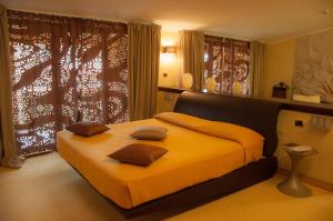 カタンツァーロ・リドにあるGrand Hotel Paradisoのベッドルーム1室(黄色いシーツ付きのベッド1台、窓付)