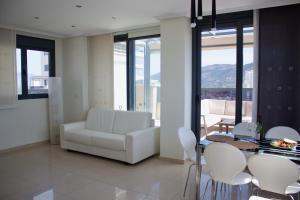 sala de estar con sofá blanco, mesa y sillas en LUXURY Residence Gemelos 26, en Benidorm