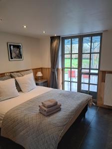 - une chambre avec un grand lit et des serviettes dans l'établissement Domein Den Buiten Bed And Breakfast DnD, à Saint-Nicolas