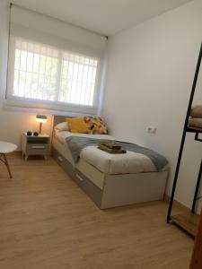 um pequeno quarto com uma cama e uma janela em Magnifico apartamento nuevo La Alberca em Múrcia
