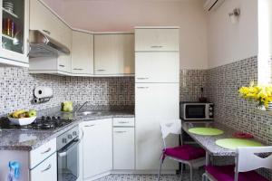 a kitchen with white cabinets and a table in it at Apartment Studio Paula in Rovinj