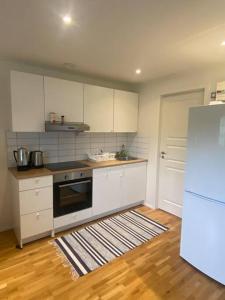 a kitchen with white cabinets and a refrigerator at Gästhus i Borås (Guest House) in Borås