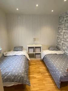 1 dormitorio con 2 camas y suelo de madera en Gästhus i Borås (Guest House) en Borås