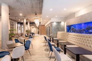 restauracja ze stołami i krzesłami oraz akwarium w obiekcie Efe Hotel & Cowork w BuenosAires