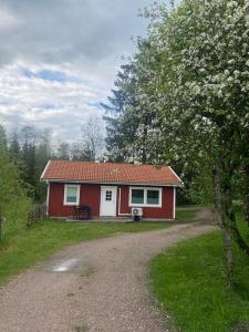 une maison rouge et blanche au milieu d'une cour dans l'établissement Gästhus i Borås (Guest House), à Borås