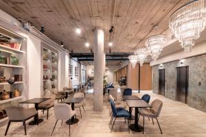 a restaurant with tables and chairs and chandeliers at Efe Hotel & Cowork in Buenos Aires