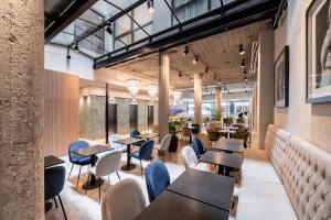 a restaurant with tables and chairs and windows at Efe Hotel & Cowork in Buenos Aires