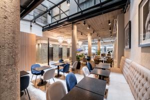 um restaurante com mesas, cadeiras e janelas em Efe Hotel & Cowork em Buenos Aires