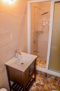 a bathroom with a sink and a shower at Beach Holidays at Marina Villa in Saint Annʼs Bay