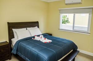 a bedroom with a blue bed with two dolls on it at Beach Holidays at Marina Villa in Saint Annʼs Bay +31 photos