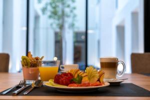 a table with a plate of fruit and two cups of juice at Efe Hotel & Cowork in Buenos Aires