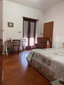 - une chambre avec un lit, une table et une chaise dans l'établissement ATOMOS, à Alvignano