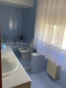 a bathroom with a sink and a toilet and a shower curtain at Villetta Girasole in Torre del Lago Puccini