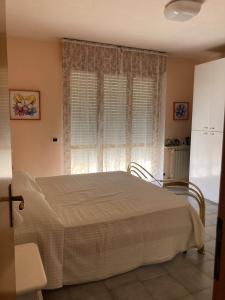 um quarto com uma cama e uma janela com cortinas em Villetta Girasole em Torre del Lago Puccini