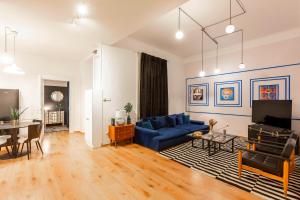 uma sala de estar com um sofá azul e uma mesa em Deluxe Dohany Residence next to the New York Café em Budapeste