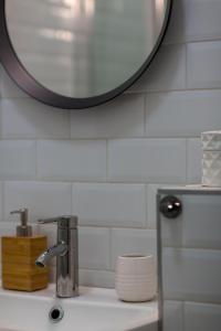 lavabo con espejo redondo encima en Deluxe Dohany Residence next to the New York Café, en Budapest