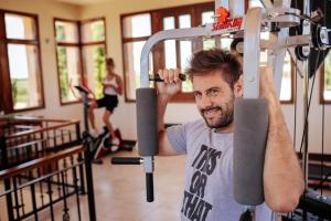 een man in een sportschool die een machine optilt bij Casa Agostino - Luxury wine and hotel in Bodega Agostino in Mendoza
