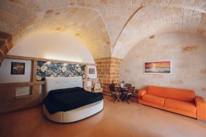 een kamer met een bed, een bank en een tafel bij La conigliera in Brindisi