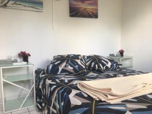 1 dormitorio con cama y mesita de noche en Appart Bleu Caraibe Bord de Mer Breakfast PROMO sur wwwvacancesenmartiniquecom, en Les Trois-Îlets