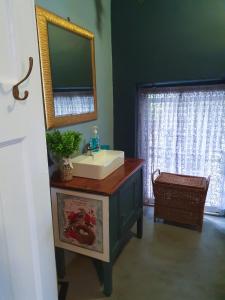 a bathroom with a sink and a mirror at Rest on 29 Rus in Oudtshoorn
