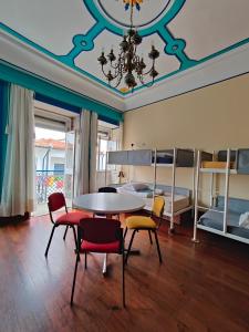 a room with a table and chairs and bunk beds at Bom Caminha - Private Albergue for Pilgrims in Caminha