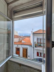 een open raam met uitzicht op een gebouw bij Bom Caminha - Private Albergue for Pilgrims in Caminha