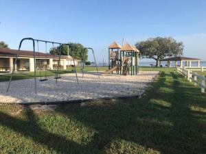 a park with a playground with a swing at Beautiful Home across the street from Lake June! in Lake Placid