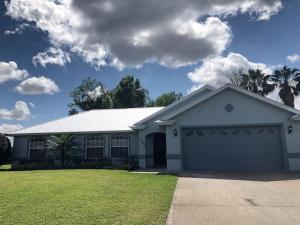 a white house with a garage at Beautiful Home across the street from Lake June! in Lake Placid