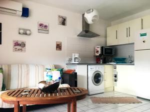 a kitchen with a table and a washing machine at Appartement lumineux à Les Trois-Îlets - 70 m² - Vue sur mer in Les Trois-Îlets +4 photos