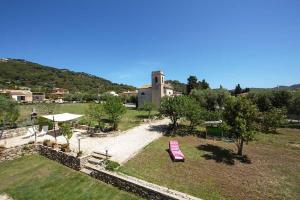 a park with a pink bench and a building at Villa Aiali in Marina di Campo