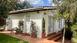 a white house with a porch with potted plants at Villette Aldobrandeschi Urban Oasis Vacation Homes in Rome