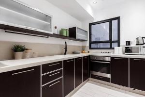 una cocina con armarios de color marrón oscuro y una ventana en Heart of Tel Aviv, apartment 2, en Tel Aviv