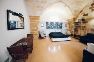 a bedroom with a bed and a table in a room at La conigliera in Brindisi