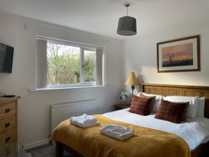 a bedroom with a bed with two towels on it at Rawtenstall bungalow. Steam train passes garden. in Rawtenstall