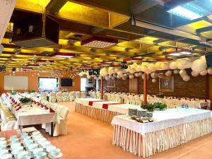 un gran salón de banquetes con mesas y sillas blancas en Ośrodek Wypoczynkowy MAX, en Jarnołtówek