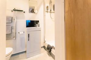 a white bathroom with a toilet and a sink at Domus House Studio Apartments Chester city centre by Rework Accommodation in Chester