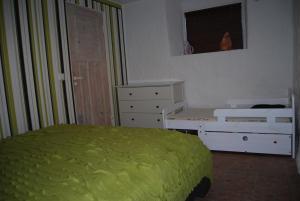 a bedroom with a bed and a dresser with a green blanket at City Centre Duplex Apartment in Tallinn