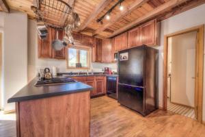 a kitchen with a stainless steel refrigerator and wooden cabinets at Stunning 360° Views - Hiker's Paradise! in Cascade-Chipita Park