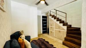 ein Wohnzimmer mit einem Sofa und einer Treppe in der Unterkunft Franks house "Shared House" in Cancún