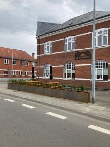 un bâtiment en briques avec des fleurs en face d'une rue dans l'établissement Signinn, à Varde