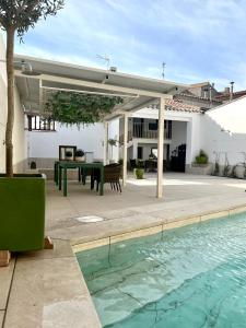 un patio con mesa y piscina en Tomé, casa de huéspedes, en Orgaz