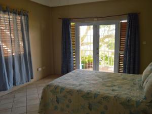 a bedroom with a bed and a sliding glass door at Seascape Villa 2BR with Stunning Caribbean Sea View in Charlotte