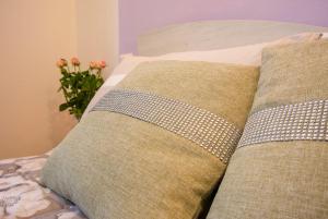 a bed with two pillows and a vase with flowers at B&B Le Rose di Gori Cristina in Pistoia