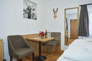 Zimmer mit einem Schreibtisch, einem Stuhl und einem Bett in der Unterkunft Gasthaus Ulrichshögl in Ainring
