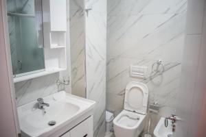 a white bathroom with a sink and a toilet at Gimi Apartments Shengjin in Shëngjin +43 photos