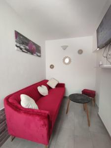 een rode bank in een woonkamer met een tafel bij B&B Dal Duca Enrico in Castelsardo